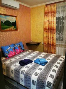 YahotynМіні КВАРТАЛ的一间卧室配有一张带蓝色枕头的大床