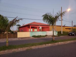 伊利亚孔普里达Casa Pestana - Ilha Comprida的街道边的红色房子
