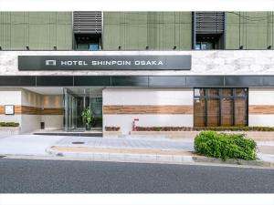 大阪HOTEL SHINPOIN OSAKA的城市街道上的酒店