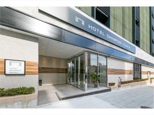 大阪HOTEL SHINPOIN OSAKA的大楼内带有标志的酒店入口