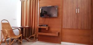 VandiperiyārCassells Jungle Resorts Thekkady的一间设有桌子的房间和墙上的电视