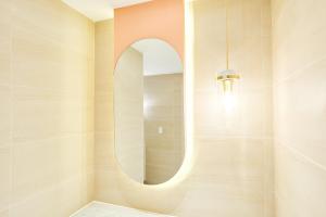 釜山西亚特B酒店的浴室的墙上设有圆形镜子