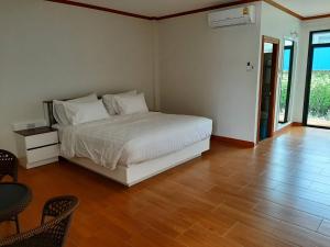 亚兰Baan Anong Hotel的卧室配有白色的床,铺有木地板