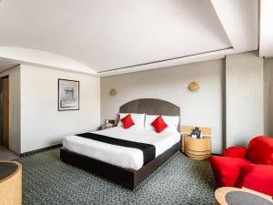 墨西哥城Capital O Andrade, Mexico City的酒店客房,配有一张床和一张红色的沙发