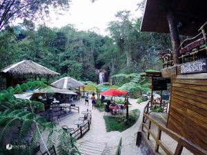 杜马格特Pulangbato Falls Mountain Resort的一群人坐在桌子上,拿着雨伞