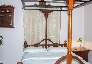孟买The Ferreiras的卧室配有带白色枕头的木制天蓬床