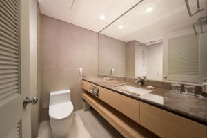 济州市济州岛阳光赌场酒店的一间带卫生间、水槽和镜子的浴室