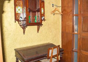 孟买The Ferreiras的一间墙上配有桌子和橱柜的房间