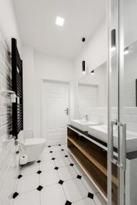 弗罗茨瓦夫Apartament SWEET TIME的白色的浴室设有卫生间和2个盥洗盆。