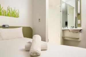 曼彻斯特曼彻斯特索尔福德码头宜必思快捷酒店的一间卧室配有一张床,床上有毛巾