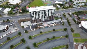 奥克兰Ramada Suites by Wyndham Manukau的享有带停车场的大楼的顶部景色