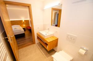 滨湖采尔Finest Villa Zell am See by All in One Apartments的一间带水槽和镜子的浴室以及一张床