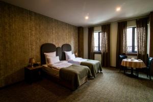 埃里温Apricot Hotel Yerevan的酒店客房带一张床、一张桌子和窗户