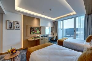 迪拜The S Hotel Al Barsha的酒店客房配有两张床和一张书桌