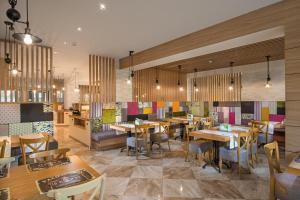 奥布佐尔Marina White Sands Beach Hotel-All Inclusive的一间设有木桌和椅子的餐厅