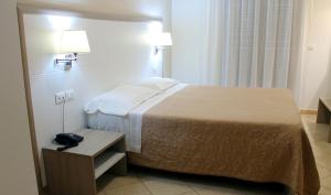 托雷桑塔萨宾娜维多利亚酒店的一间酒店客房,配有一张床铺和一张桌子上的电话