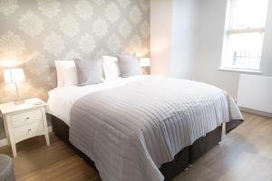剑桥Citystay - Hinton House的卧室配有一张带白色棉被的大床