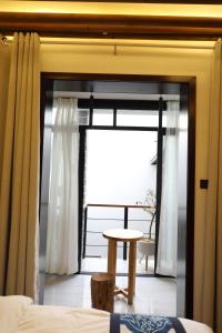 西安大风起西民宿的客房设有带桌子和床的窗户。
