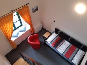 TřemošniceWellness hotel Lihovar的享有高空美景,设有两张床和一张红椅。