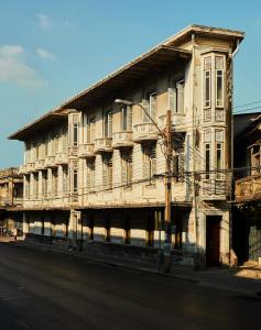 曼谷The Mustang Blu的街道边的一座古老的木结构建筑