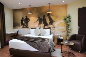 阿比让Le Wafou的卧室配有一张床,墙上挂有绘画作品