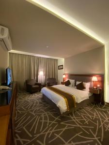 哈伊勒Desert Rose的酒店客房设有一张大床和一张沙发。