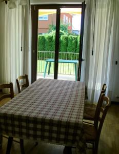 加尔达湖滨Villa Berta的一张桌子,上面有一张格子桌布,放在窗前