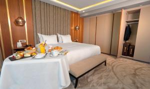 卡萨布兰卡安法宫酒店的酒店客房,配有床和餐桌,上面有食物