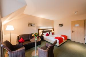迪楚姆Hotel am Fischerhafen的酒店客房,配有床和沙发
