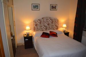 达罗Weir view Bed and Breakfast的一间卧室配有一张带两个红色枕头的床