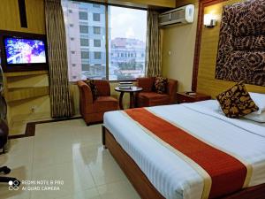 达卡Marino Hotel - Best near Airport的一间酒店客房,配有一张床和一台电视