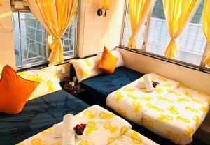 香港David Lounge的配有黄色窗帘的客房内的两张床