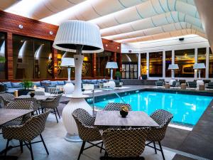 卡尔加里艺术酒店的酒店大堂设有游泳池和桌椅