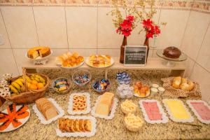 阿帕雷西达Pousada Santa Cruz的填满不同种类面包和其他食物的桌子