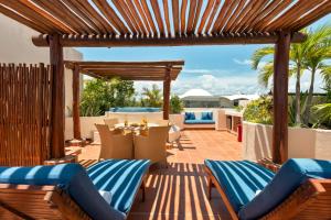 普拉亚卡门波尔图海滩公寓酒店及海滩俱乐部的庭院设有木制凉亭和桌椅