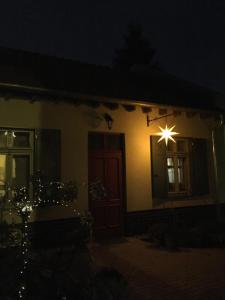 波茨坦Ferienwohnung Kamp "Blick ins Grüne"的夜晚窗户上灯的房子