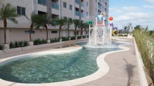 萨利诺波利斯Salinas Park Resort - Apartamento inteiro Frente Mar的建筑物前泳池中的喷泉