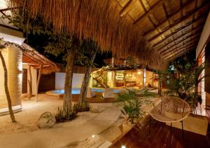 图卢姆Mimosa Tulum的一个带游泳池和草屋顶的度假胜地
