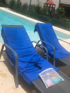布宜诺斯艾利斯Studio Torre Rio - IMPECABLE STUDIO, LUMINOSO, CHIC - EXCELENTE UBICACIÓN - PALERMO的游泳池畔的两把蓝色沙滩椅