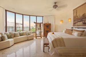 普拉亚卡门波尔图海滩公寓酒店及海滩俱乐部的一间卧室配有一张大床和一张沙发
