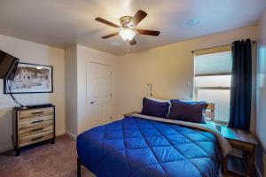 摩押Rim Vista 11A2的一间卧室配有蓝色的床和吊扇