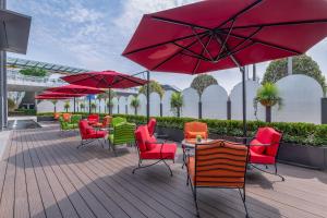 上海上海中庚聚龙酒店的一个带桌椅和红色遮阳伞的庭院