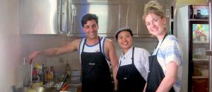 普卢坎普里达桔马海滩生态度假酒店的三人站在厨房里