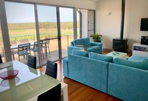 勒弗戴尔阿迪娜葡萄园别墅的一间带蓝色沙发和桌子的客厅以及一个阳台