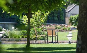 桑畔斯蒙特乔利城堡酒店的一个带长凳、桌子和鲜花的公园