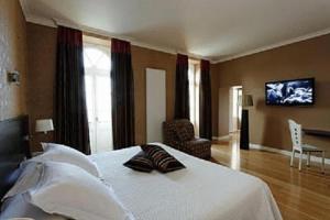 桑畔斯蒙特乔利城堡酒店的卧室配有一张床,墙上配有电视。