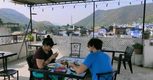 本迪石瓦图瑞斯特旅馆的两个人坐在阳台上的桌子上吃食物