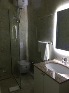 地拉那Ramel Hotel的一间带水槽、卫生间和淋浴的浴室