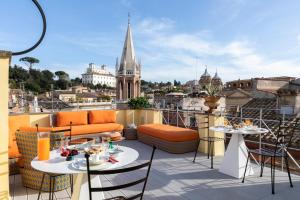 罗马Poēsis Experience Hotel的设有带桌椅的市景阳台。