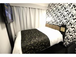 丰桥市APA Hotel Toyohashi-Ekimae的一间卧室配有一张带黑白毯子的床